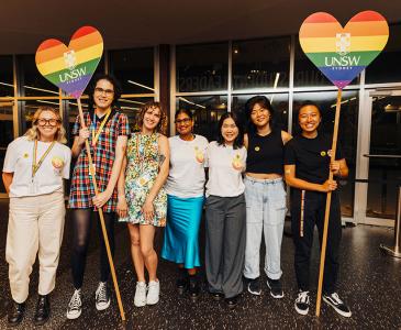 UNSW staff holding rainbow flag hearts at the Minus18 Queer Formal