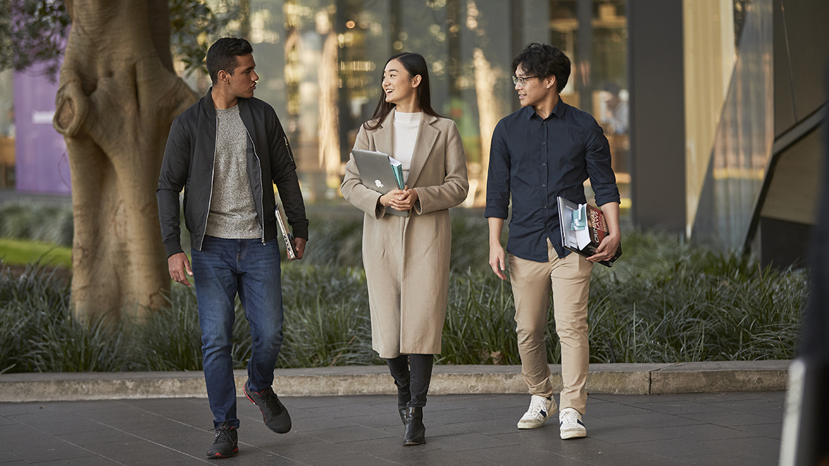 Three Law students walking near the Law & Justice building