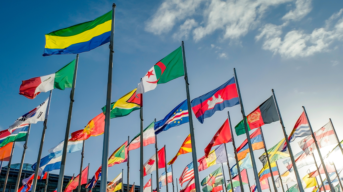 International flags flying against a blue sky