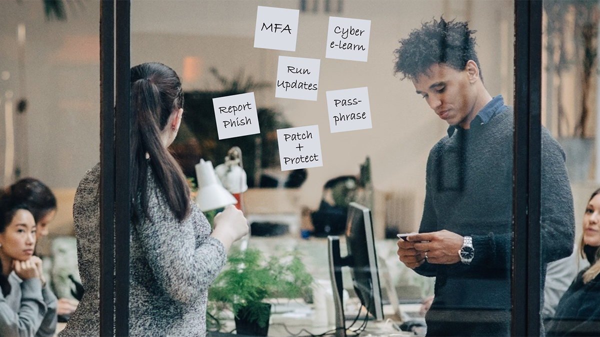 A group of people behind a window covered in notes featuring words related to cyber security