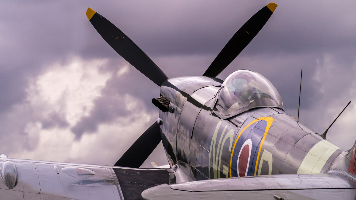 Spitfire plane on the tarmac against a cloudy sky