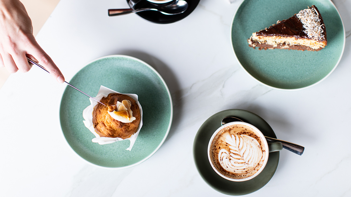 Coffee cup, muffin and cake on a white table