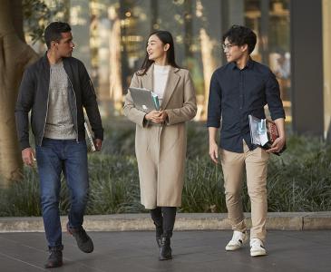 Three Law students walking near the Law & Justice building