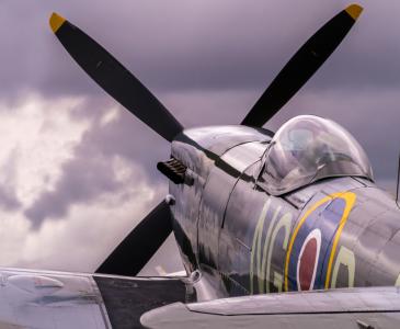 Spitfire plane on the tarmac against a cloudy sky