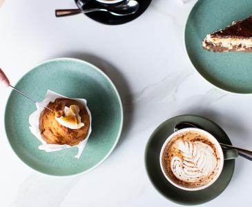 Coffee cup, muffin and cake on a white table