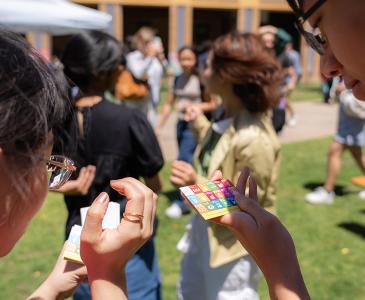 Two people holding cards with SDGs represented