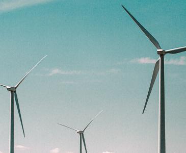 Three wind turbines against a blue sky