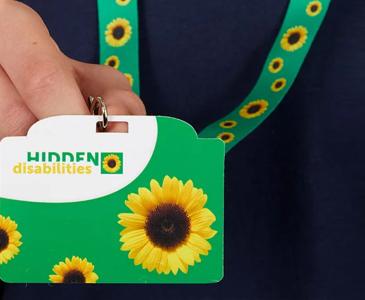 A person holding a Sunflower initiative card and lanyard