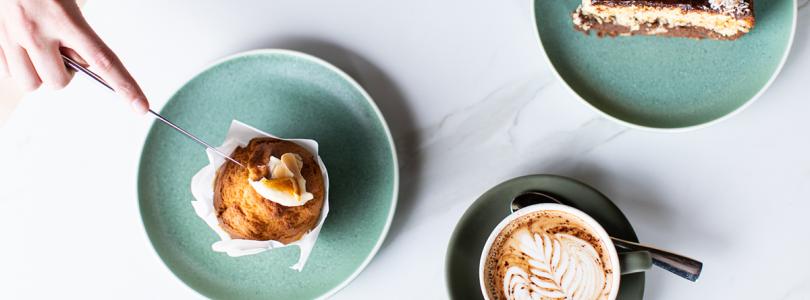 Coffee cup, muffin and cake on a white table